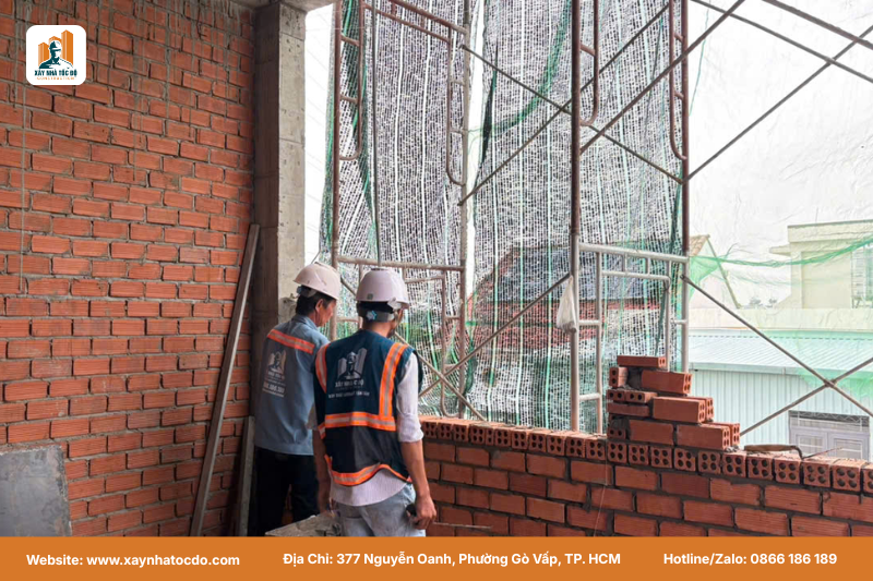 Thợ xây đang thi công tường gạch thẳng tắp theo đúng quy trình thi công thô của Xây Nhà Tốc Độ.