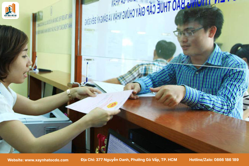 Hình ảnh một người đang nộp bộ hồ sơ hoàn công tại quầy dịch vụ công.