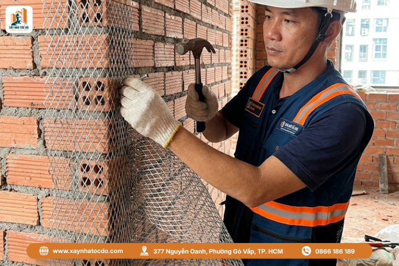Thợ thi công đang thực hiện kỹ thuật đóng lưới mắt cáo lên tường gạch.